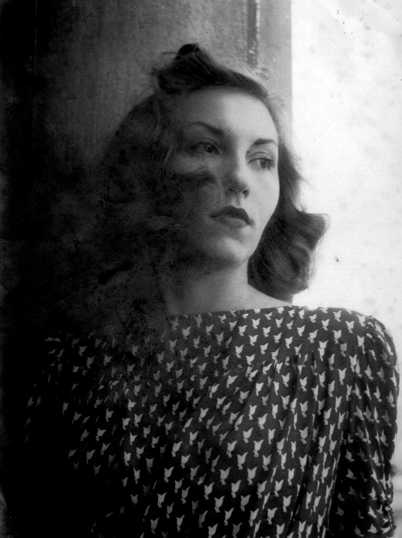 Black and white photograph of Clarice Lispector wearing a printed blouse with curled hair